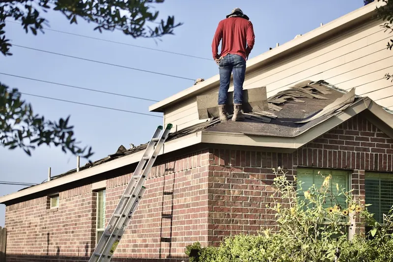 Professional roofer working on a residential roof in Bryan